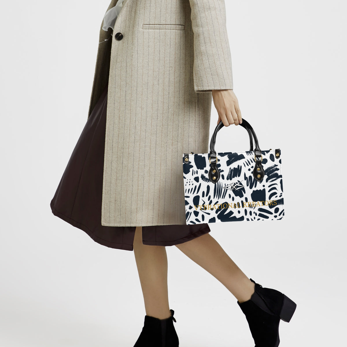 Kreator Luxe tote bag by Vybrational Kreators featuring a black and white abstract pattern structured shape black top handles gold hardware and printed brand logo.