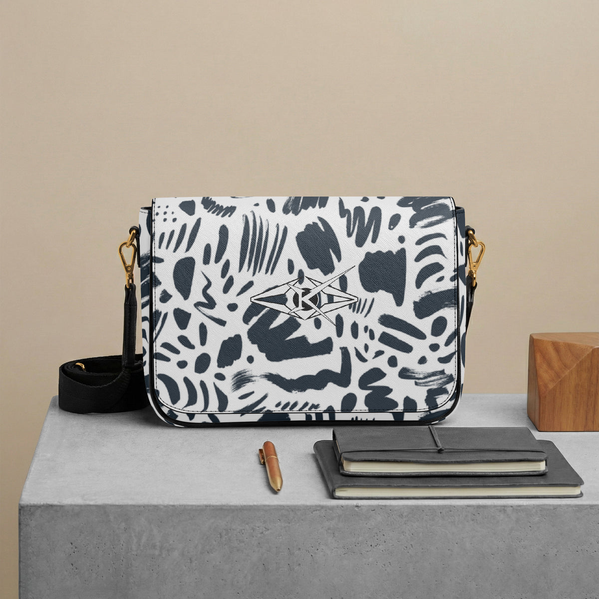 Patterned handbag on a table with a pen and notebook