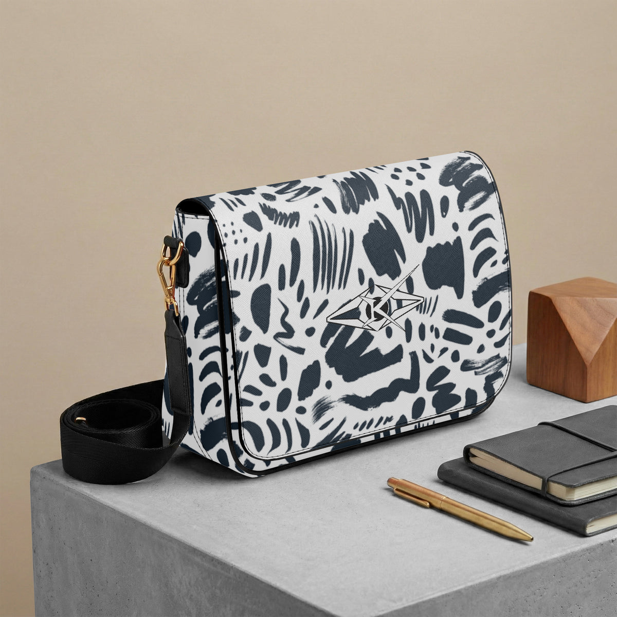 White handbag with black abstract patterns on a gray surface with a beige background