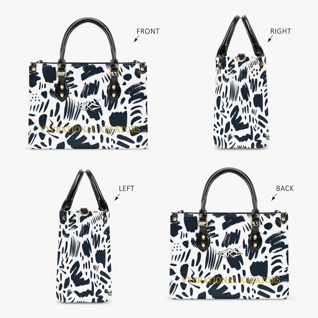 Kreator Luxe tote bag by Vybrational Kreators featuring a black and white abstract pattern structured shape black top handles gold hardware and printed brand logo.