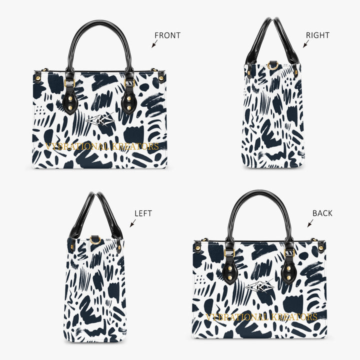 Kreator Luxe tote bag by Vybrational Kreators featuring a black and white abstract pattern structured shape black top handles gold hardware and printed brand logo.