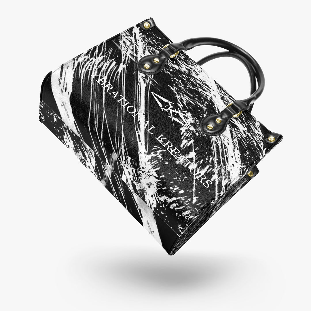 Onyx Flow Luxe tote bag by Vybrational Kreators featuring a black and white abstract flow pattern structured silhouette black top handles gold hardware and printed brand logo.