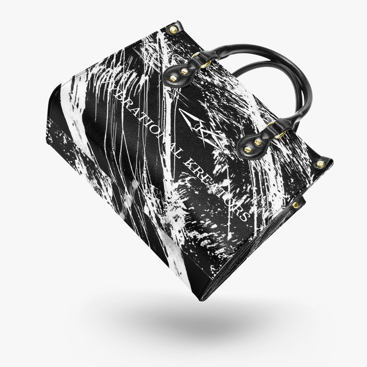 Onyx Flow Luxe tote bag by Vybrational Kreators featuring a black and white abstract flow pattern structured silhouette black top handles gold hardware and printed brand logo.