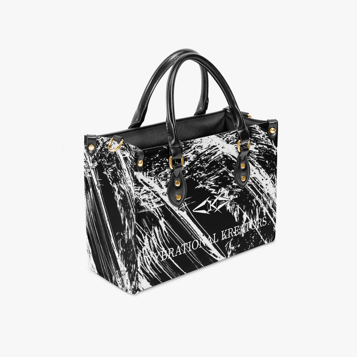 Onyx Flow Luxe tote bag by Vybrational Kreators featuring a black and white abstract flow pattern structured silhouette black top handles gold hardware and printed brand logo.